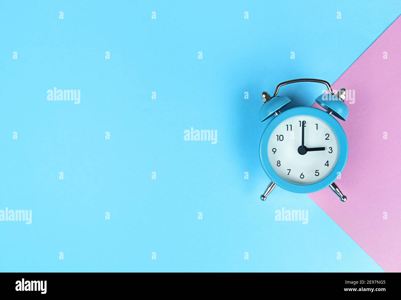 Retro alarm clock on blue background with copy space. Stock Photo