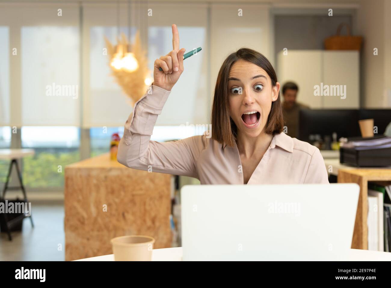 Inspired hispanic woman having an idea while looking her laptop in the office. Stock Photo