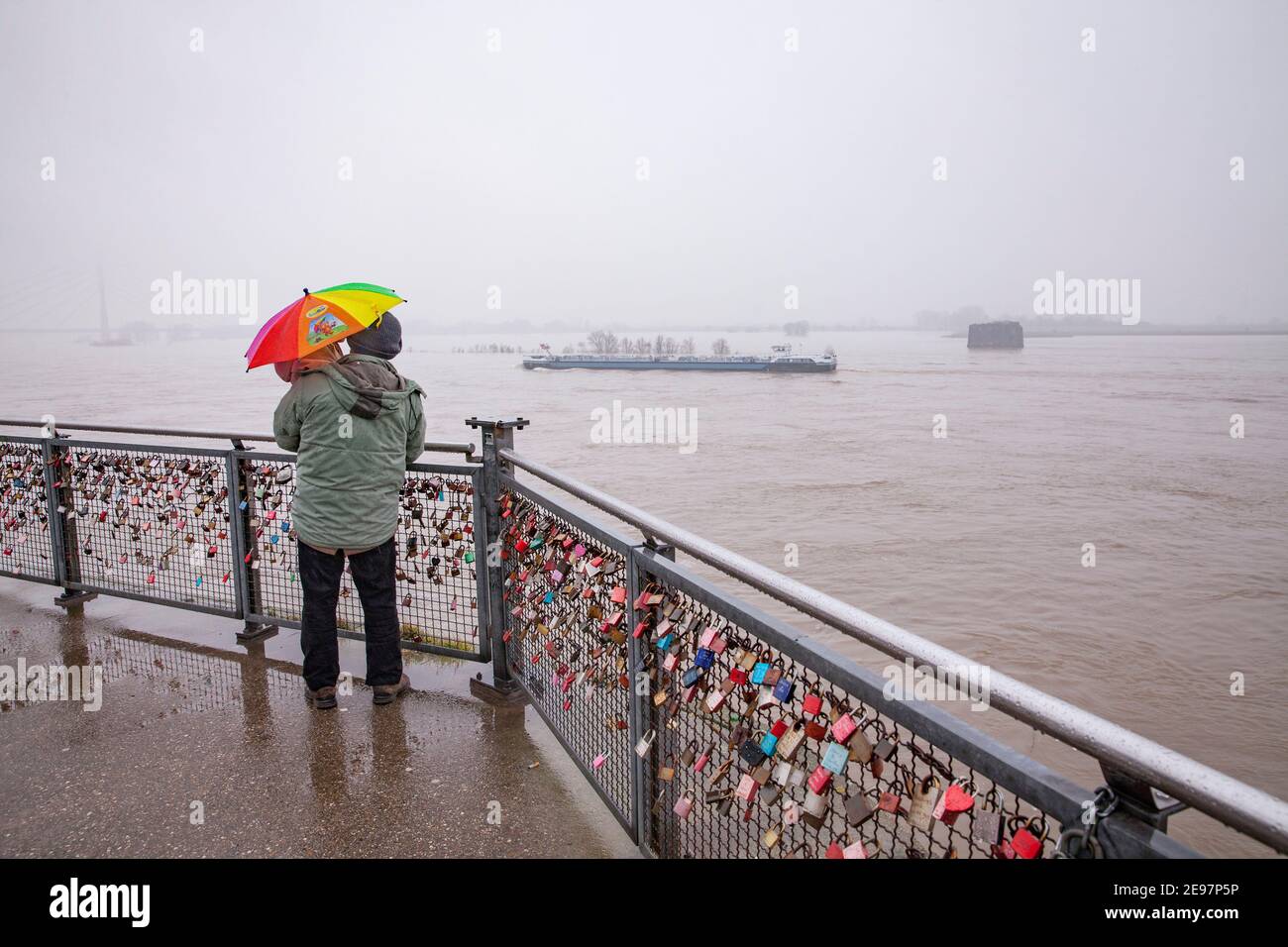 flood of the river Rhine in Wesel on the Lower Rhine on 2 February 2021, man with child looking at the Rhine from the old bridge pier, North Rhine-Wes Stock Photo
