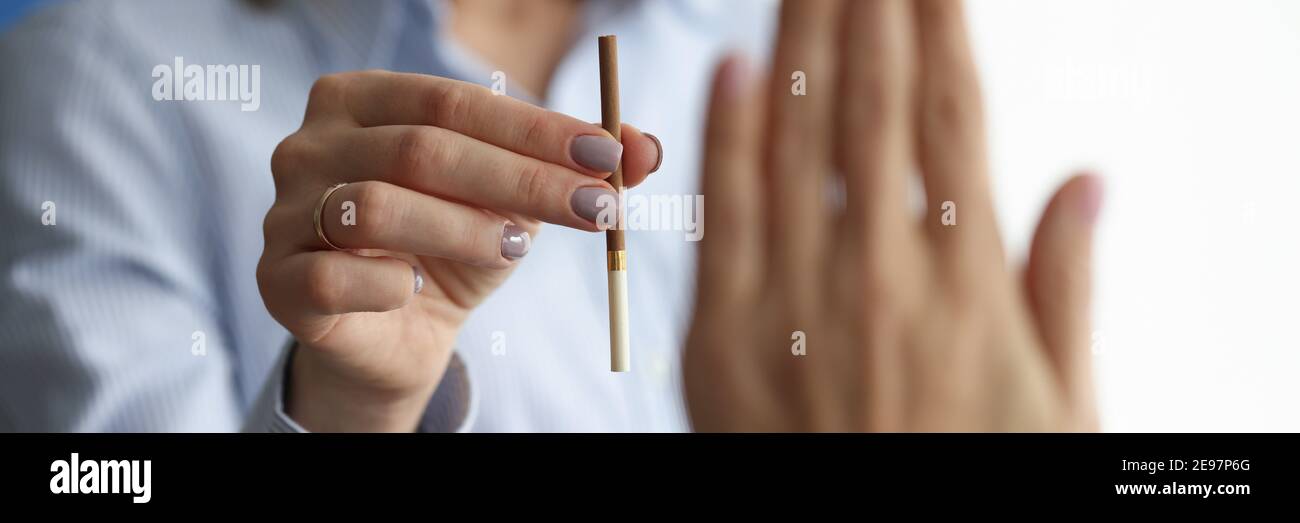 Woman offers cigarette to man who makes negative gesture. Stock Photo