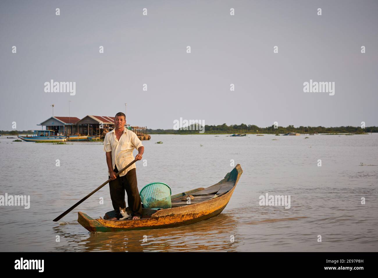 A Vietnamese man on Tonlé Sap lake with his cat. Stock Photo