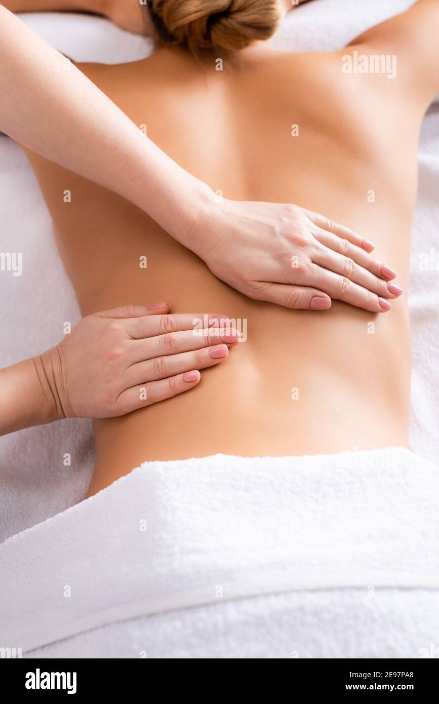 partial view of masseur massaging client on massage table Stock Photo