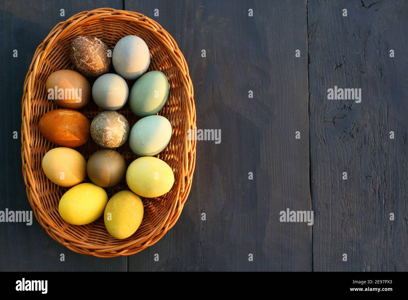 Naturally dyed Easter eggs in the basket background. Stock Photo