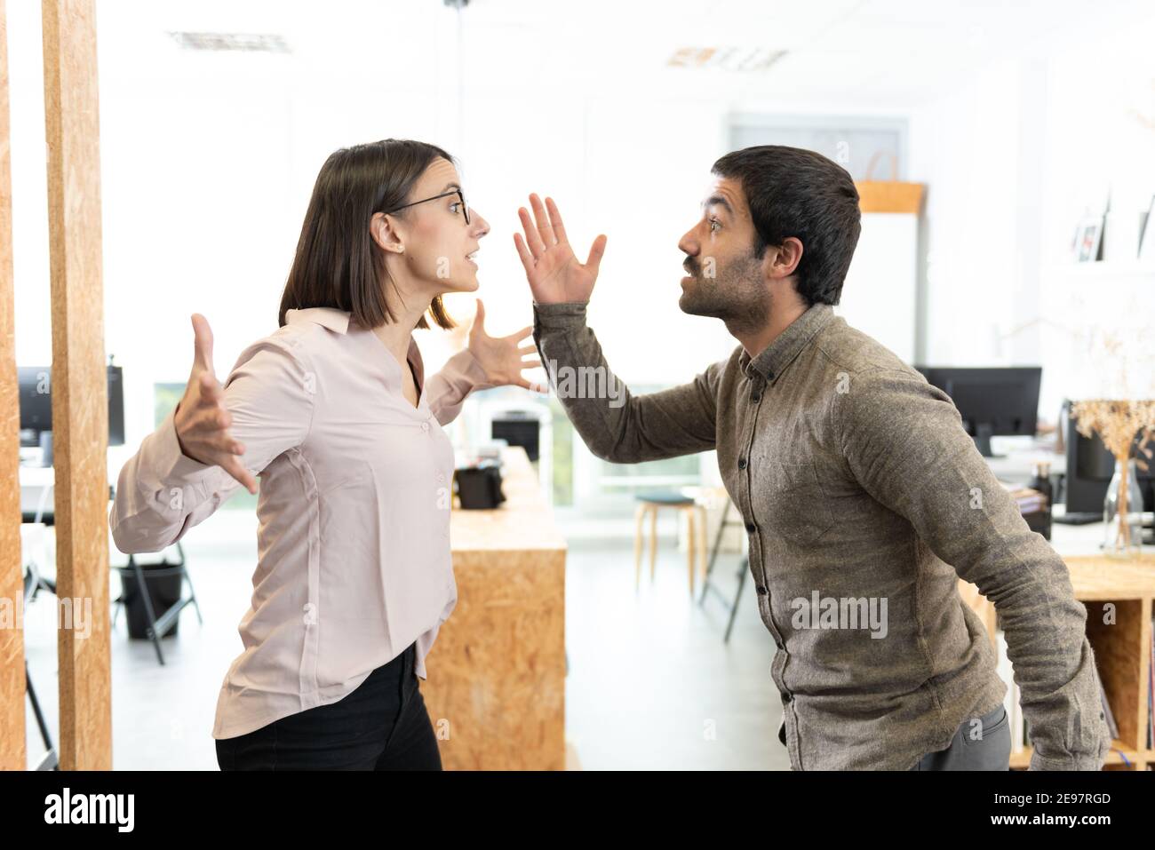 Angry hispanic coworkers discussing and arguing at the office. Stock Photo