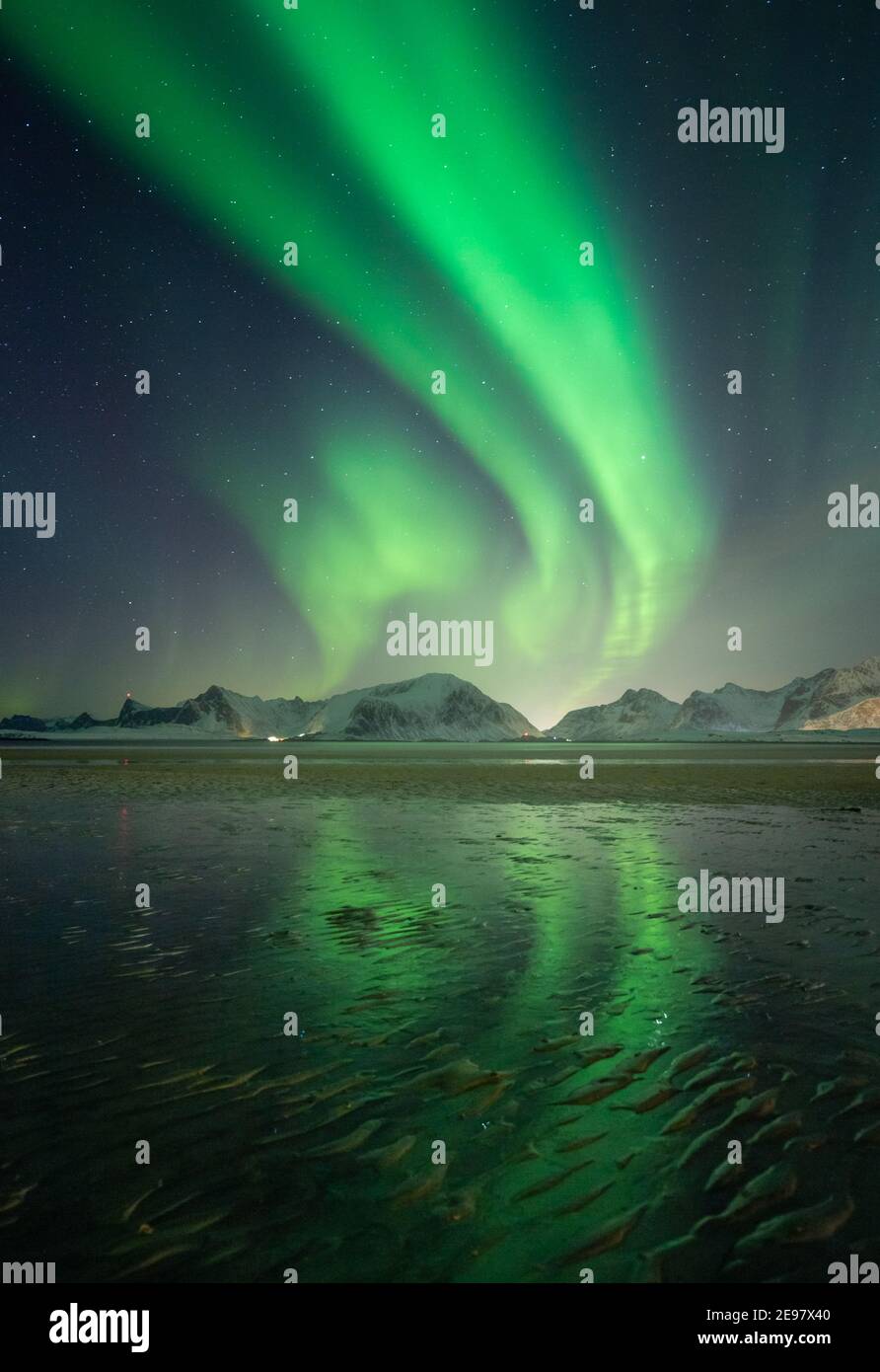 Northern Lights above mountains on Lofoten Islands. Reflections of