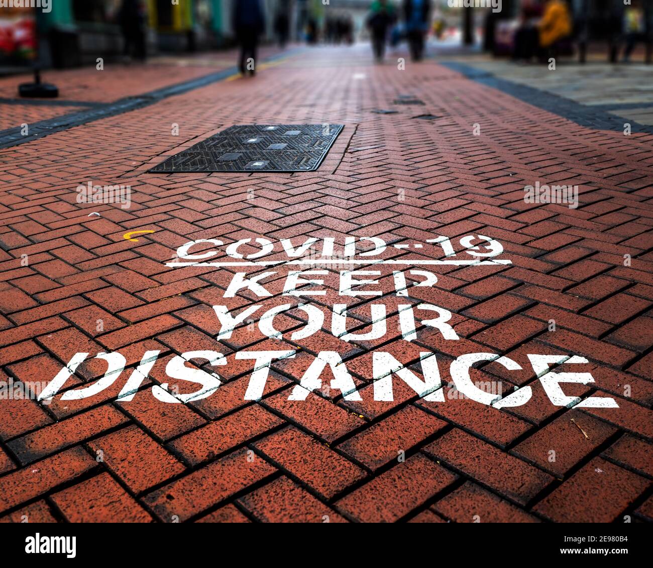 Covid-19 distancing warning signs painted on UK pedestrian area. New Street, Birmingham, West Midlands. Stock Photo