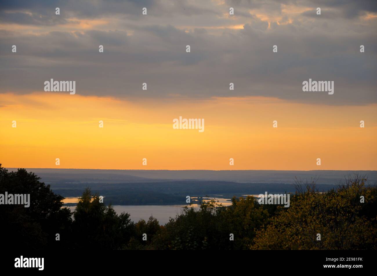 Colorful autumn landscape at sunset, view of the sunlit hills, the river below and the misty distance on the horizon Stock Photo