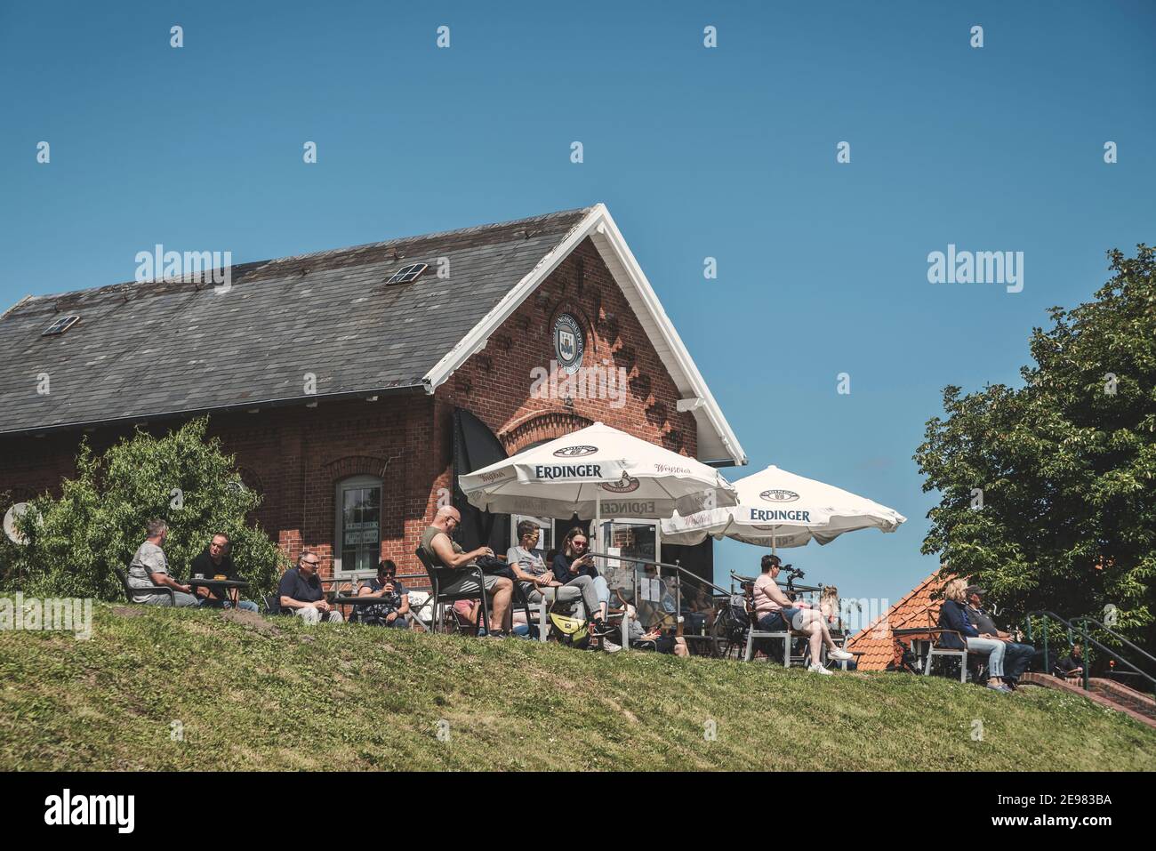 People sitting in the cafe at the flood embankment, Greetsiel, Lower Saxony, Germany, Europe Stock Photo