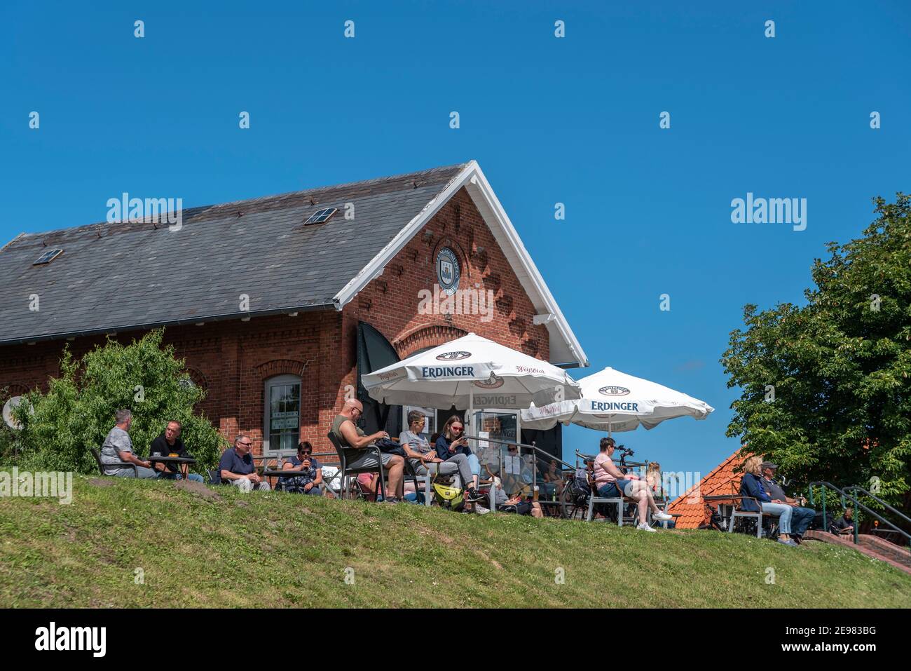 People sitting in the cafe at the flood embankment, Greetsiel, Lower Saxony, Germany, Europe Stock Photo