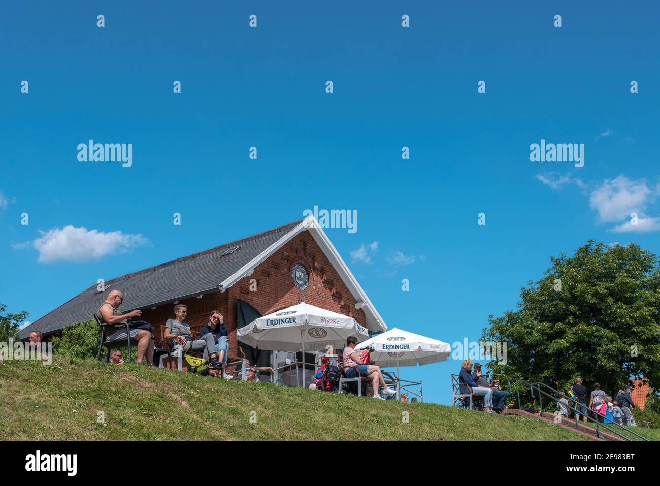 People sitting in the cafe at the flood embankment, Greetsiel, Lower Saxony, Germany, Europe Stock Photo