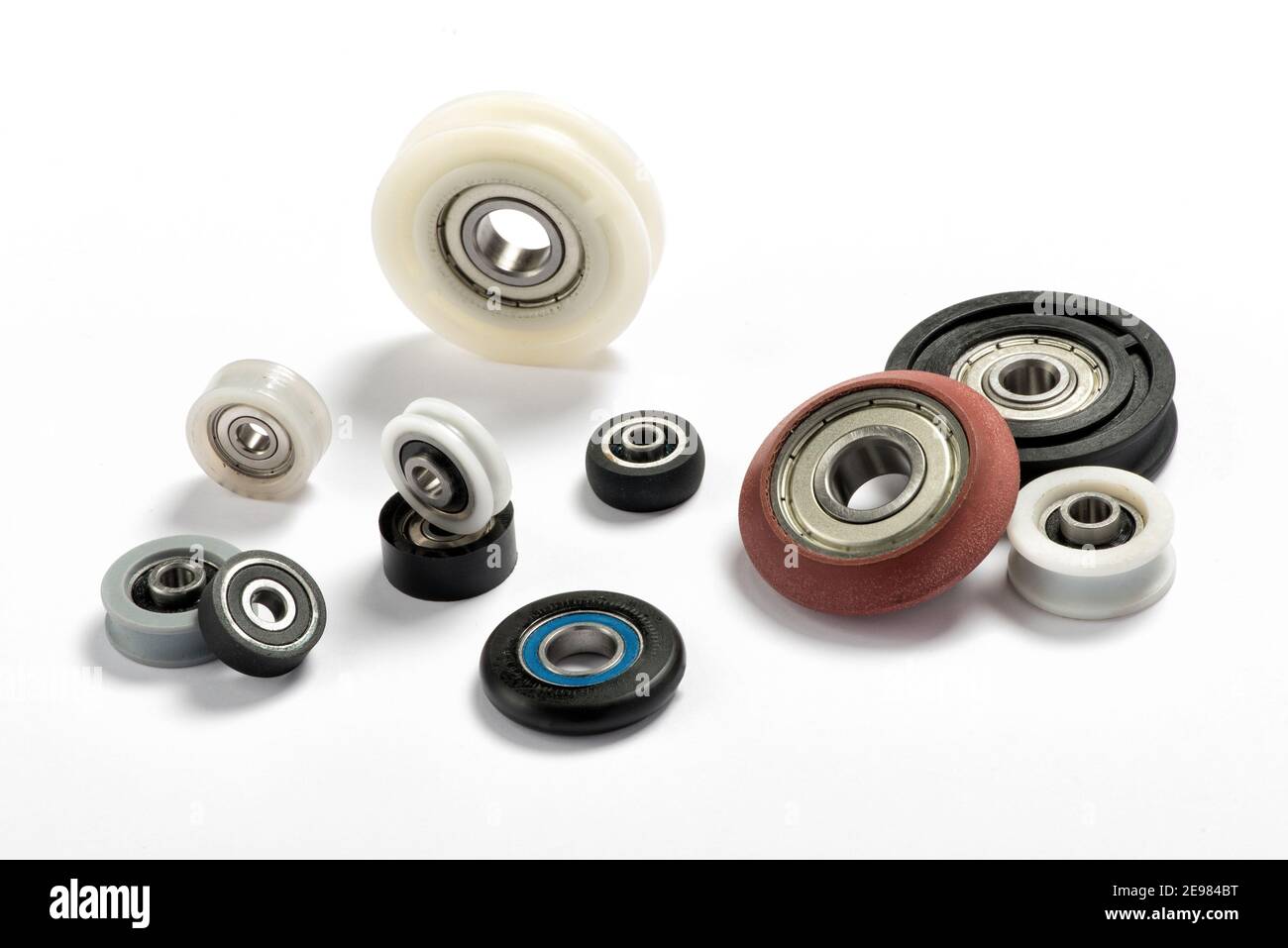Minimalistic composition with assorted ball bearings of different colors and sizes arranged on white background for industry and engineering concept Stock Photo