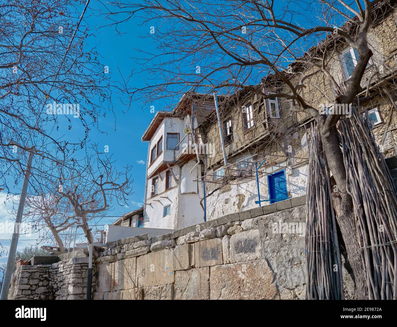 Old town Golyazi. Ancient and magnificent house in front of the lake of uluabat during sunny day. House made of stone and mud as old style. Blue door Stock Photo