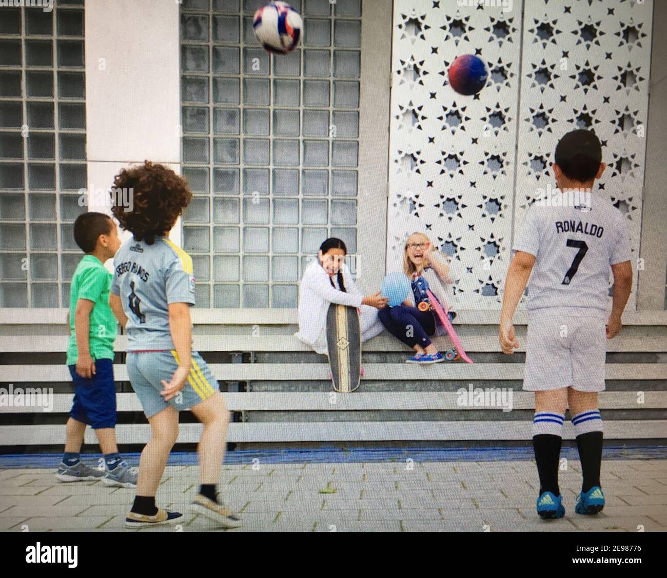 Mosque, children play, football, street photography Stock Photo