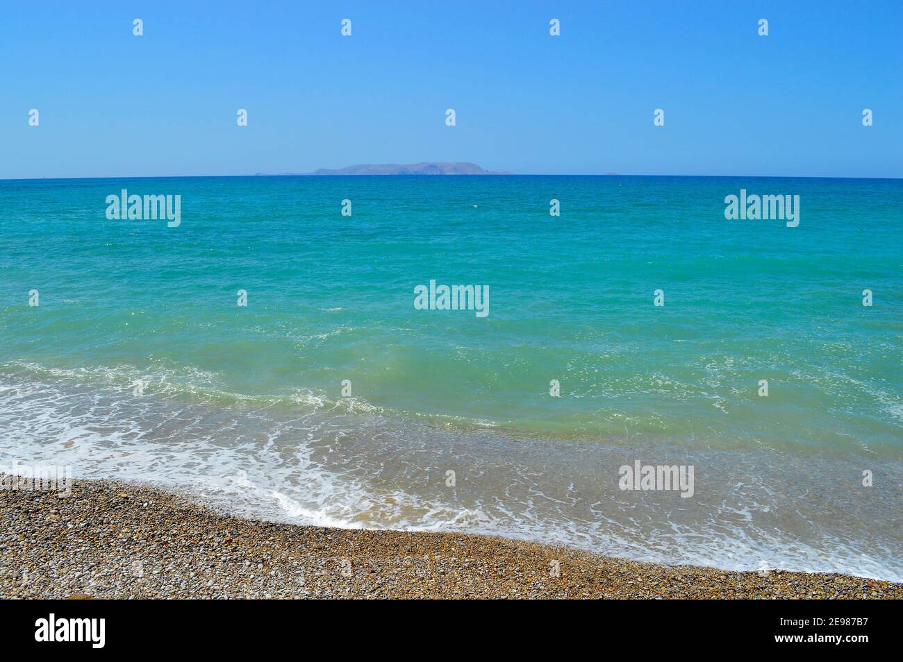 Kato Gouves pebble beach in Crete with the island of Dia on the horizon