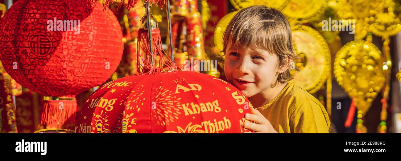 BANNER, LONG FORMAT Caucasian tourist boy in Tet holidays. Vietnam Chinese Lunar New Year in springtime. TEXT TRANSLATION from Vietnamese Stock Photo