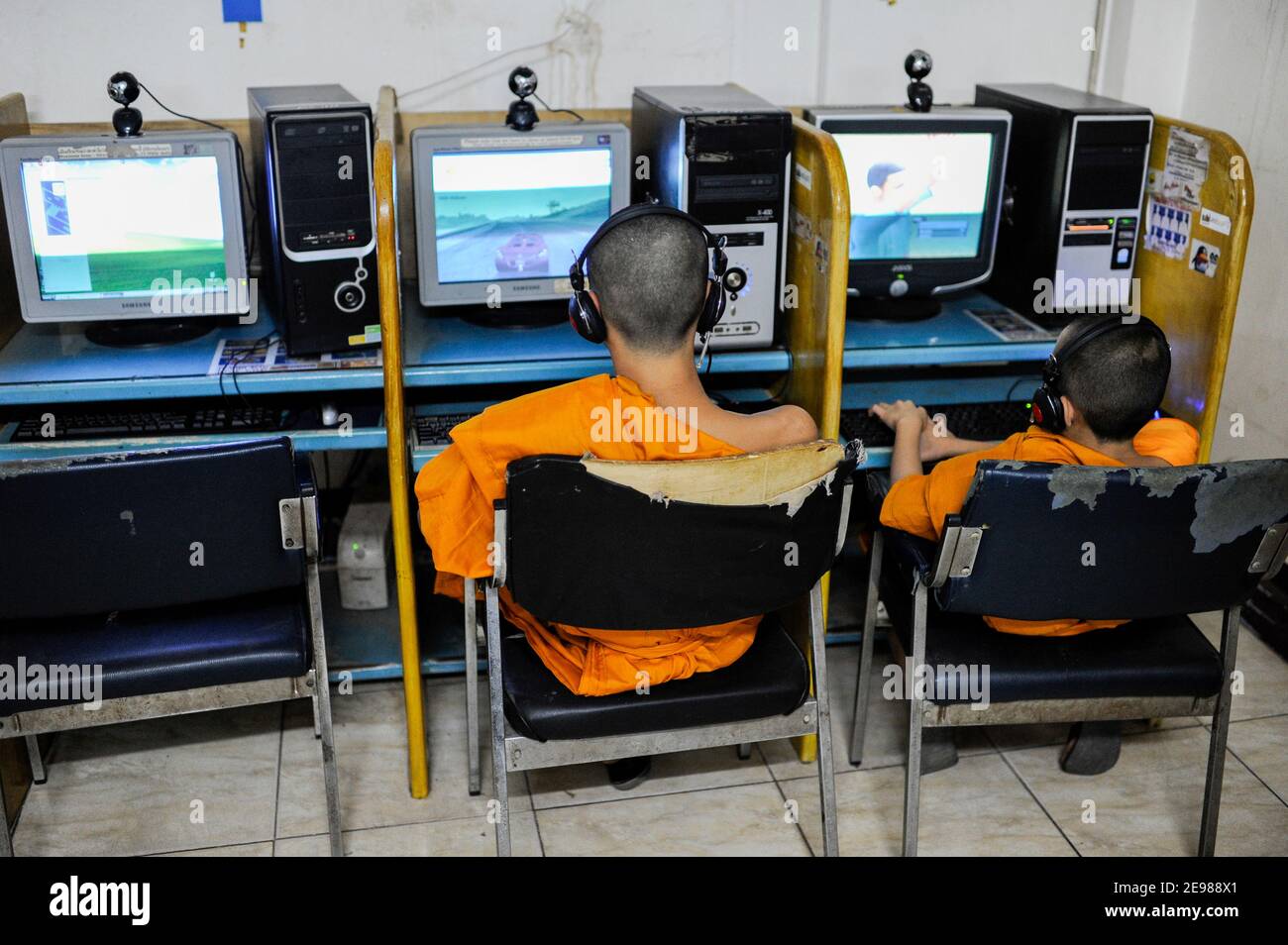 LAO PDR, Vientiane, young buddhist monk in Cybercafe playing games at computer / LAOS Vientiane , junge buddhistische Moenche spielen Computerspiele in einem Internet Cafe Stock Photo