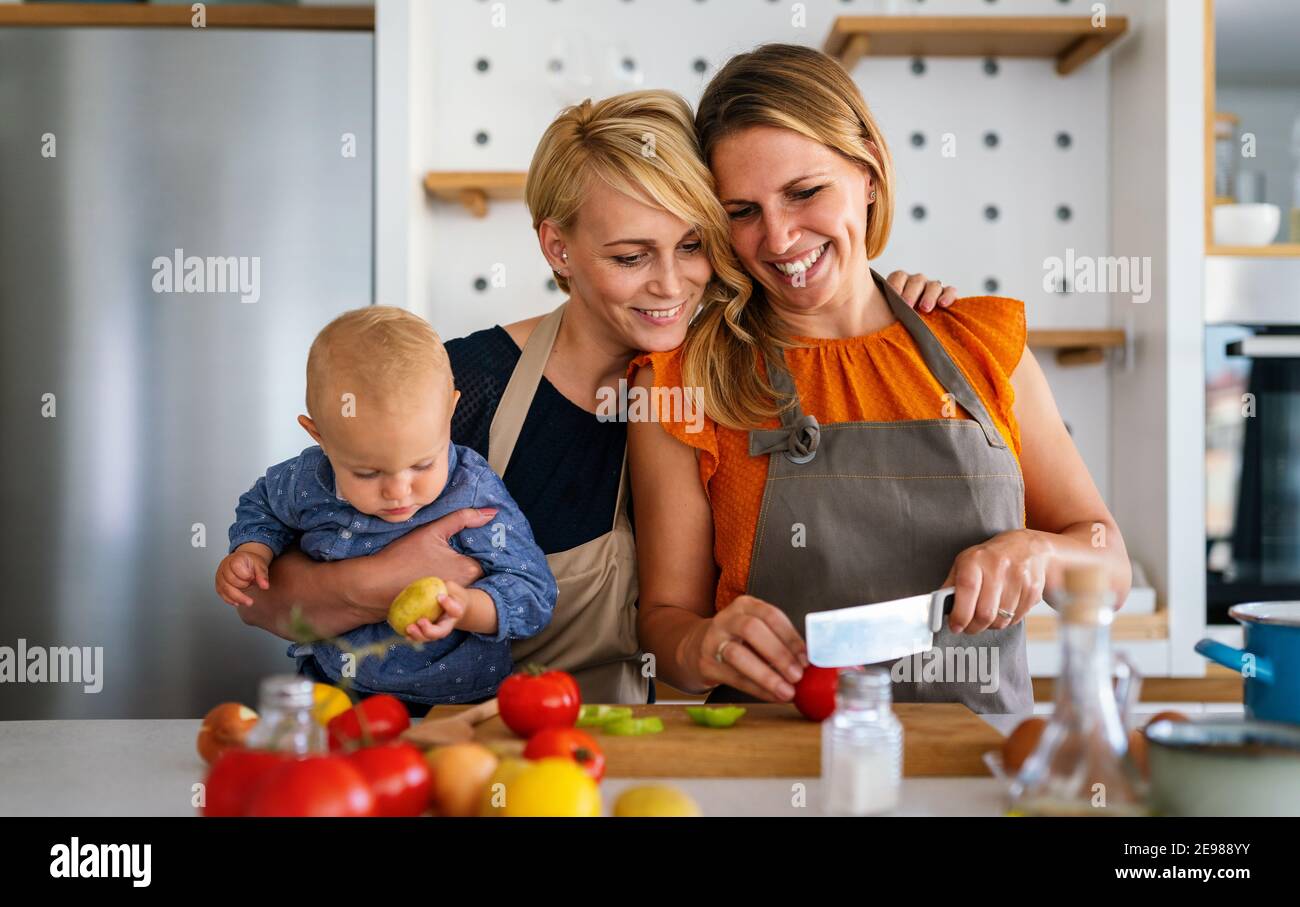 Lesbian mothers with adopted child. Happy homosexual family playing with her daughter Stock Photo