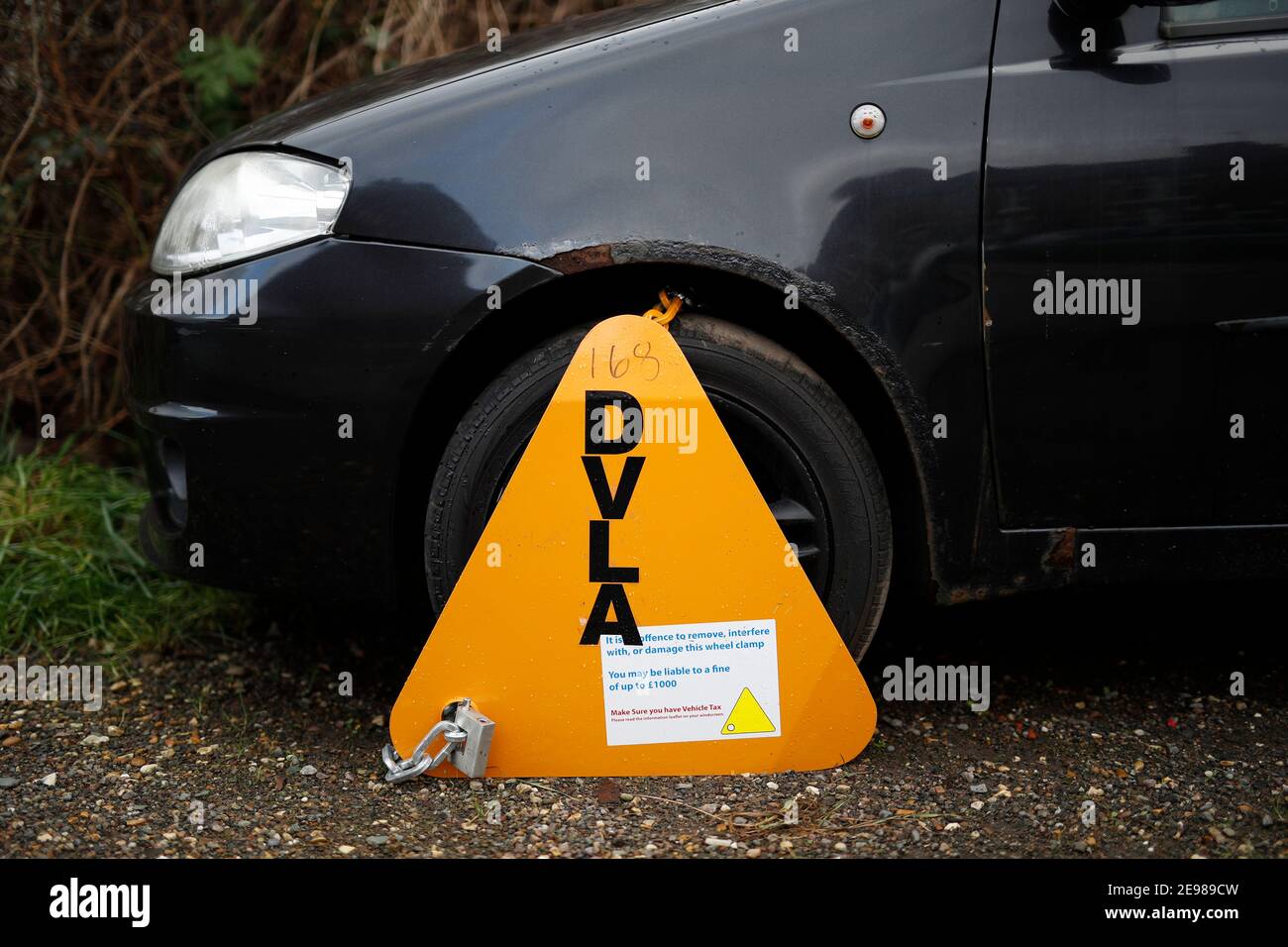 Loughborough, Leicestershire, UK. 3rd February 2021. A Fiat Punto car stands immobilised by a DVLA clamp for having no road tax.  Credit Darren Staple Stock Photo