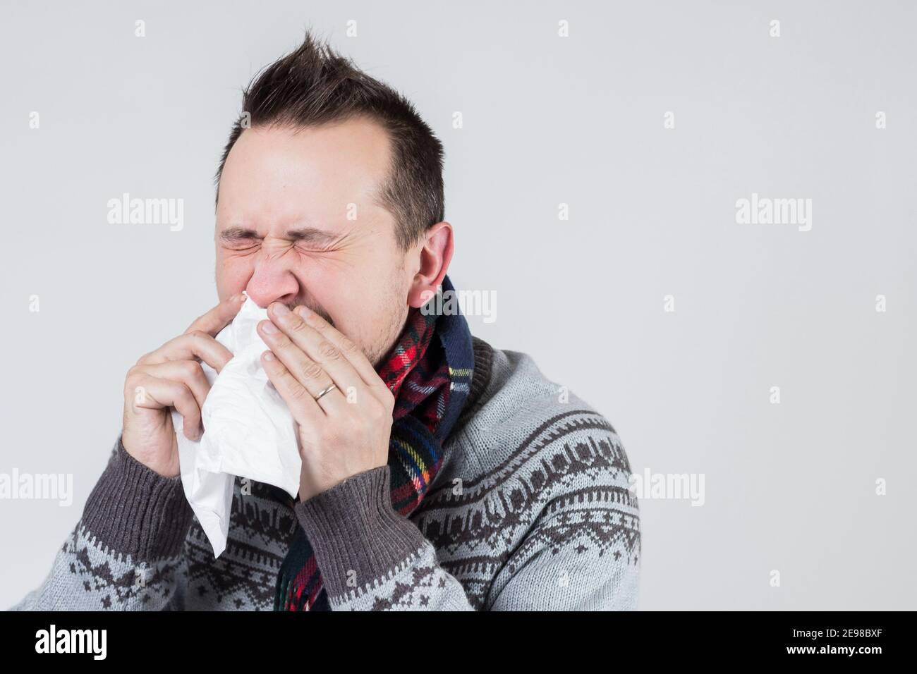 young european man blows his nose in a handkerchief Stock Photo