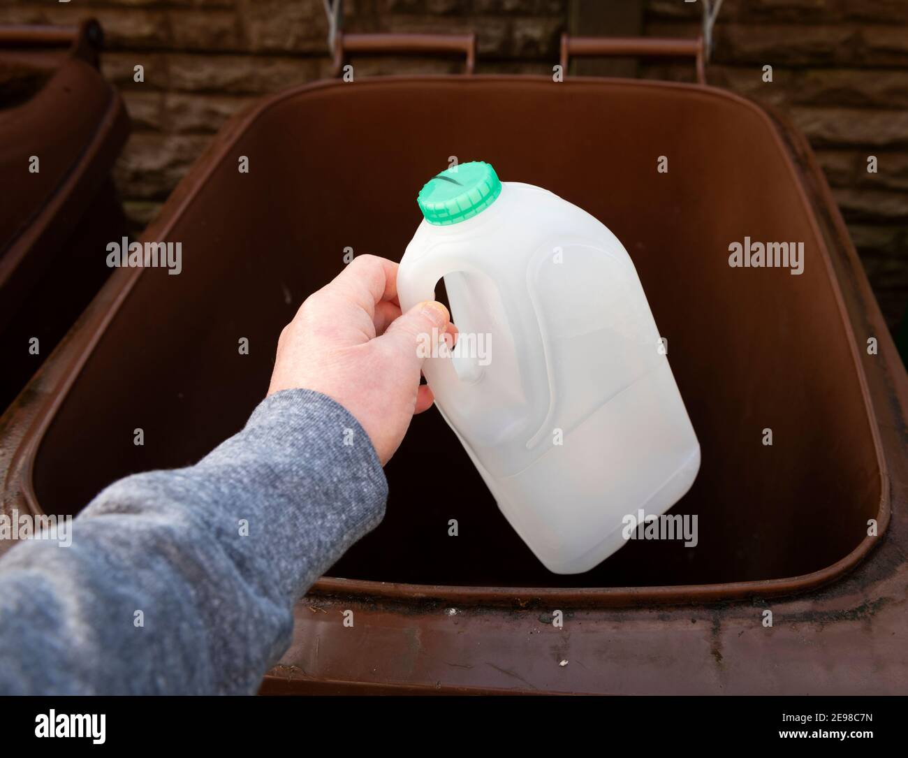 Throwing away a plastic milk bottle for recycling Stock Photo