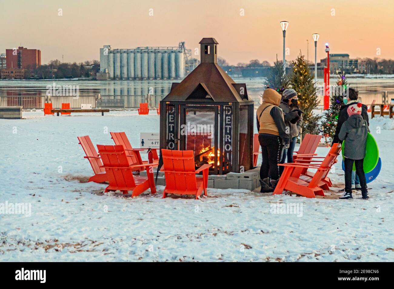 Detroit, Michigan - A family by a fire at Robert C. Valade Park on the east riverfront. The park, part of the Detroit Riverfront Conservancy, programs Stock Photo