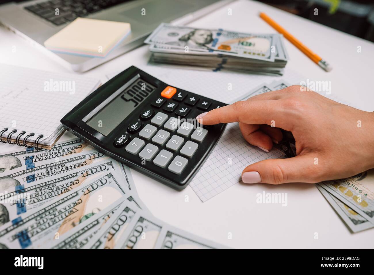 Closeup of old analog calculator. Young woman counts numbers on device