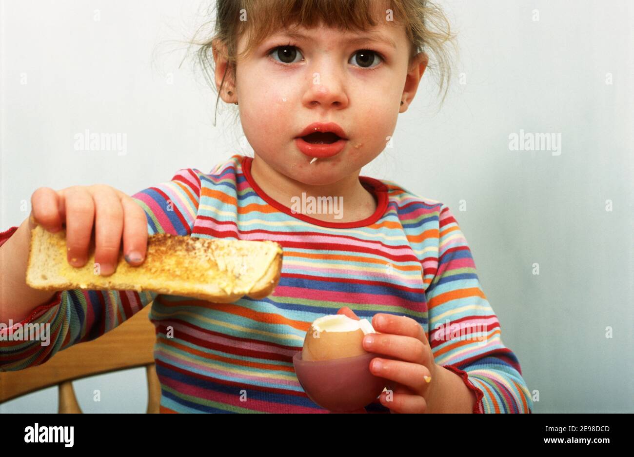 3year old girl eating a boiled egg for breakfast Stock Photo Alamy