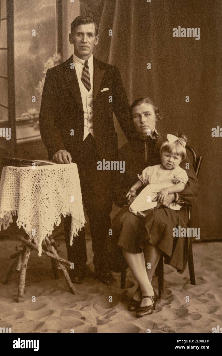 Germany - CIRCA 1930s: A family studio shot of married couple with a child in studio. Vintage art deco era photo Stock Photo