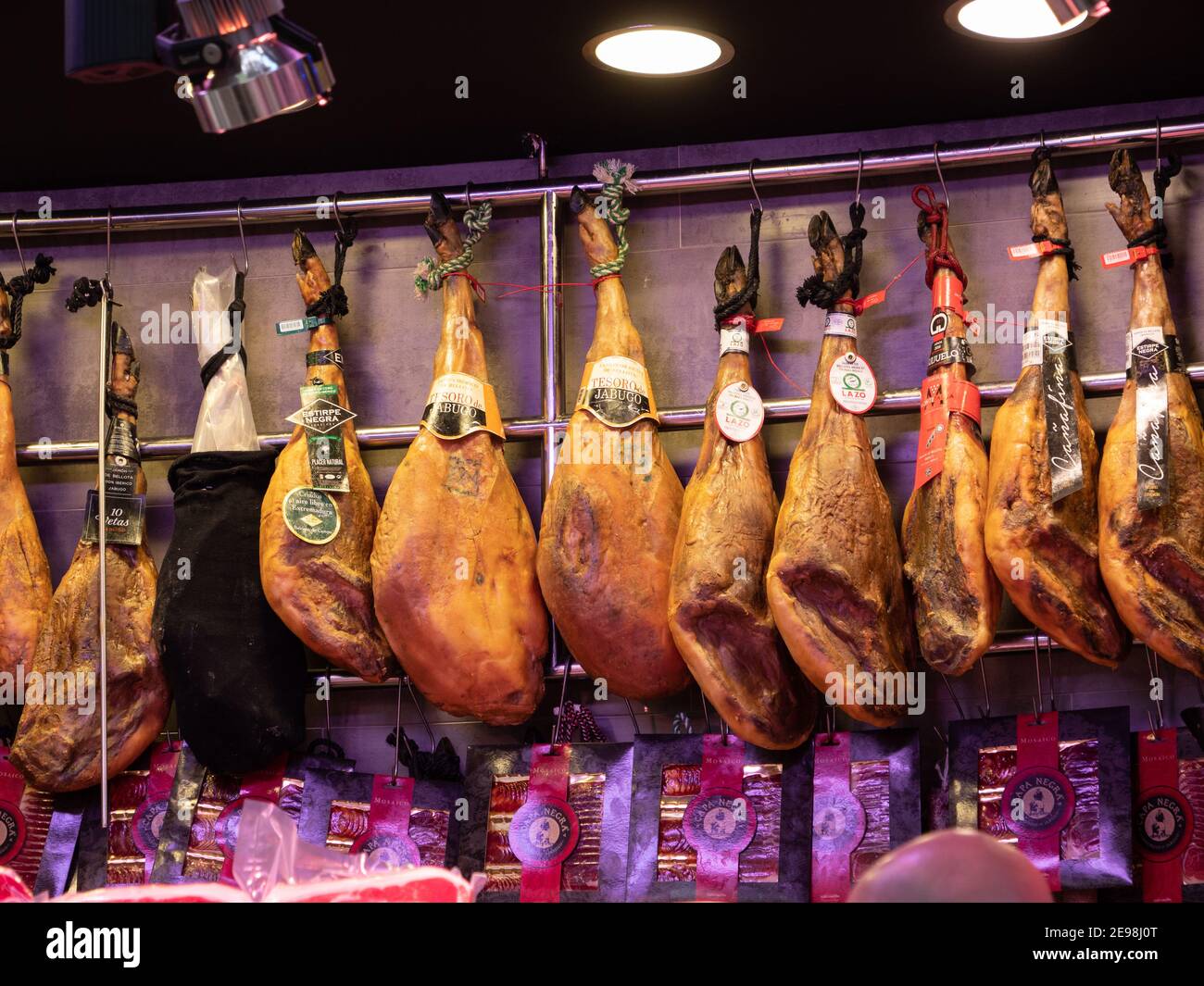 Dry cured serrano ham joints displayed in a market in Valencia Spain