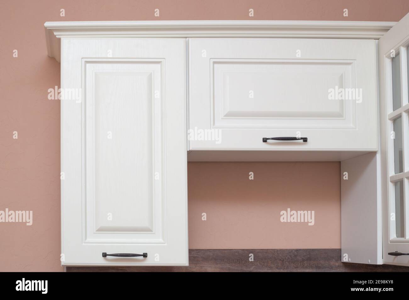 White kitchen cabinets on the background of a beige wall. Kitchen interier. Stock Photo