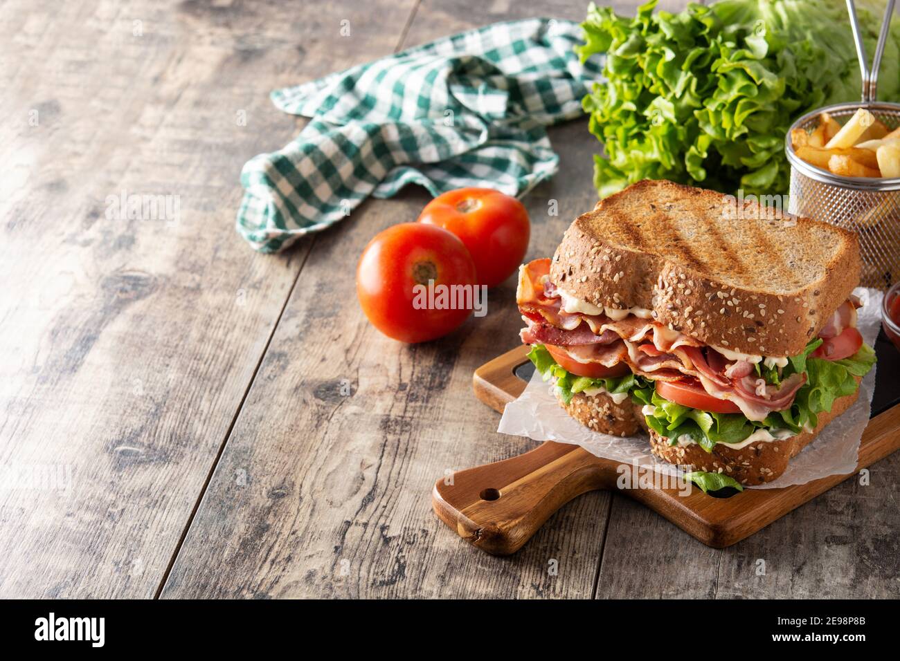 BLT sandwich and fries on wooden table Stock Photo