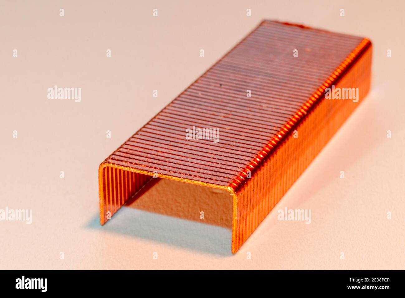 Coppered staples photographed closeup in white tones. Group of copper