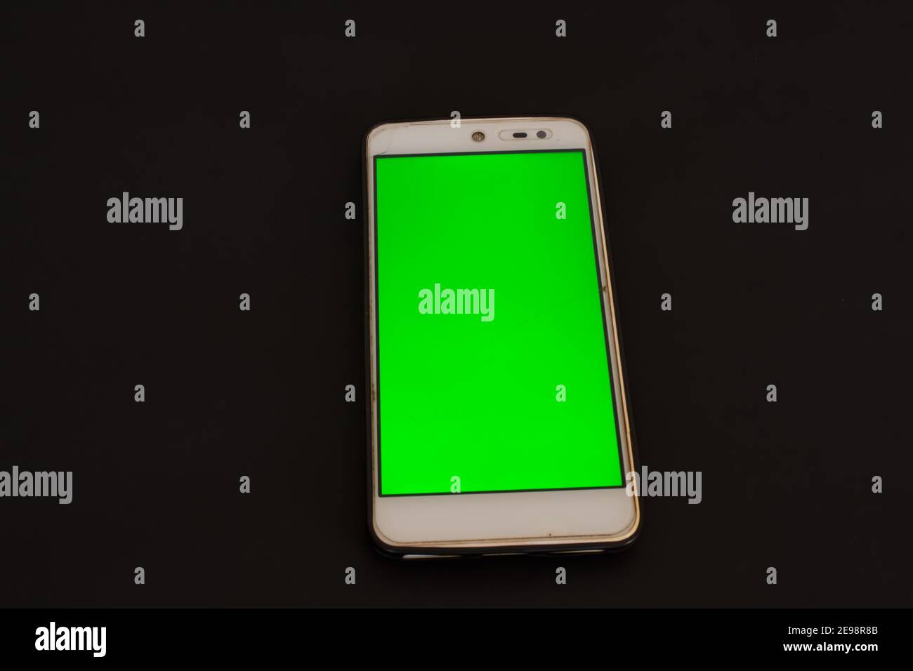 Smartphone with green screen on black background. Stock Photo