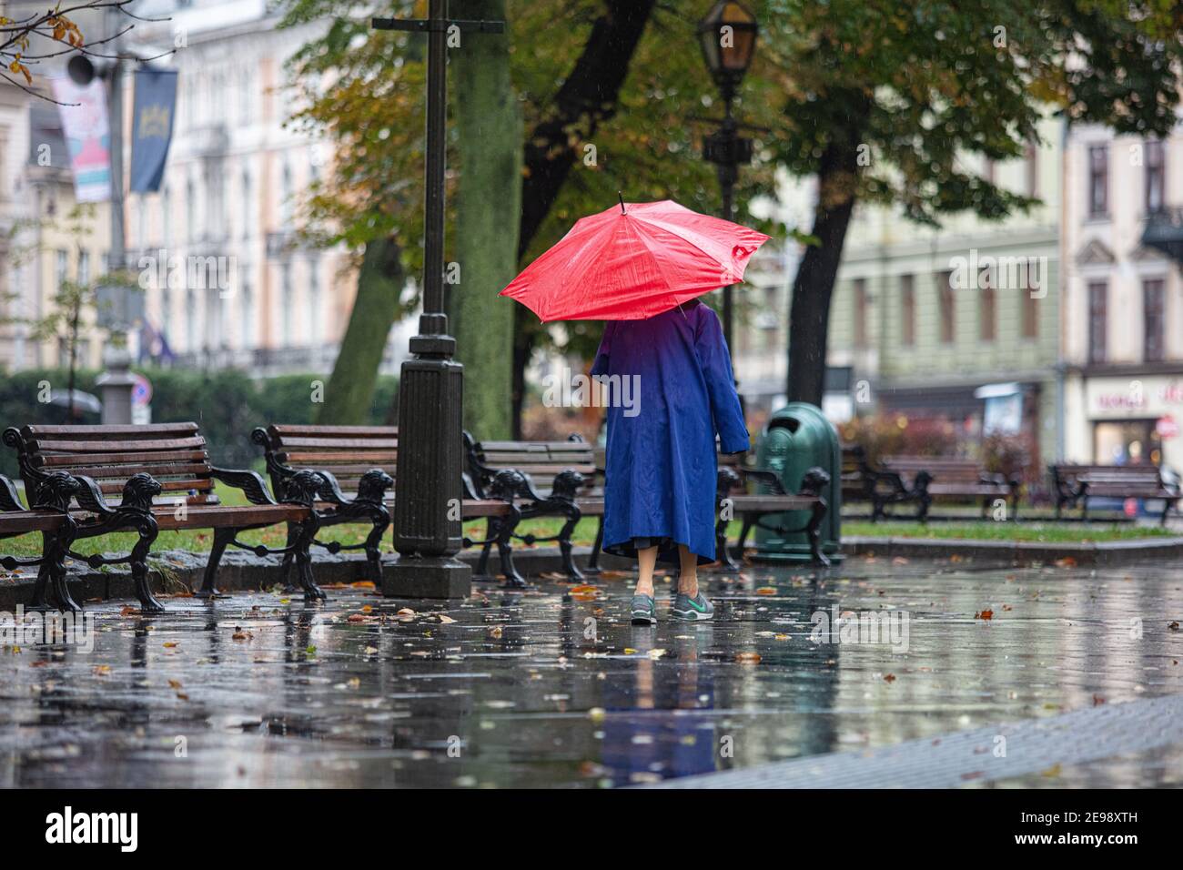 Lviv, Ukraine - September 30, 2020: senior woman wearing Nike sneakers and  red umbrella walking on rainy street Stock Photo - Alamy