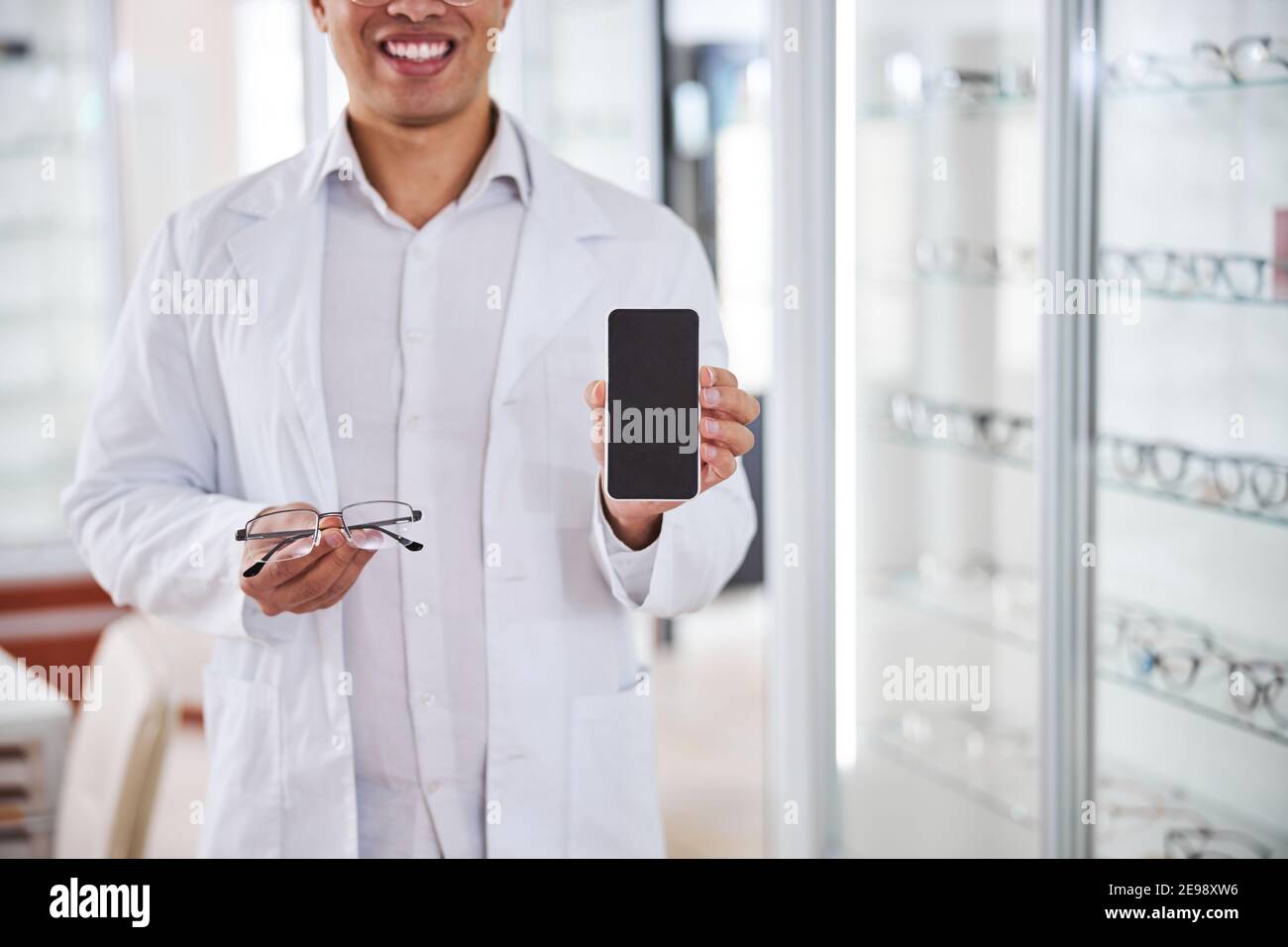 Optical dispenser offering a new pair of glasses Stock Photo Alamy