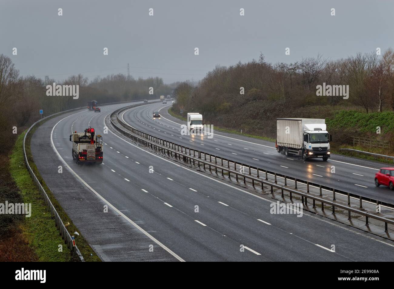 Traffic on the M3 motorway on a dull grey wet winters day, Shepperton Surrey England UK Stock Photo