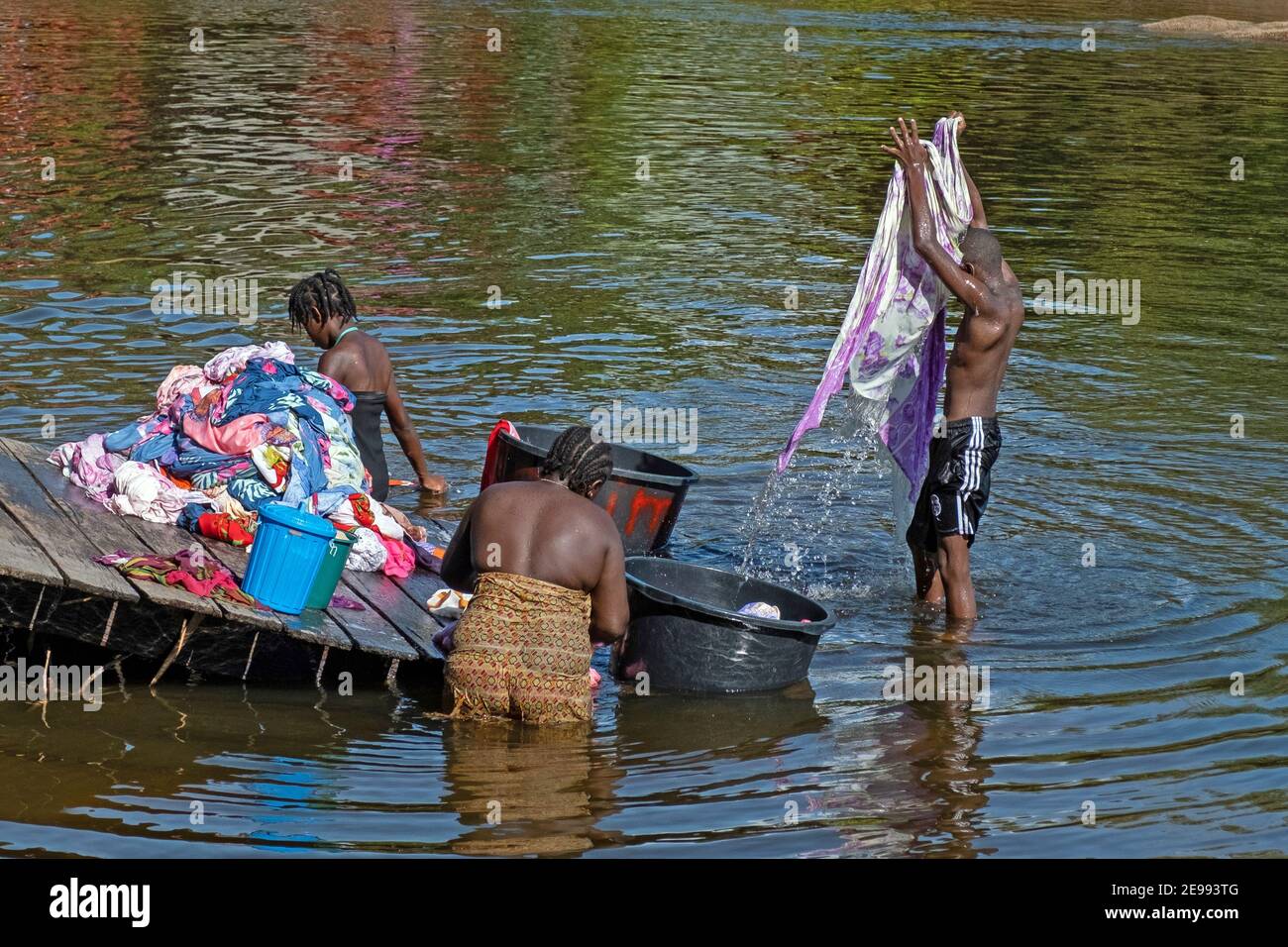 Afro-Surinamese family washing clothes in the Suriname River near Aurora, Sipaliwini District, Suriname / Surinam Stock Photo