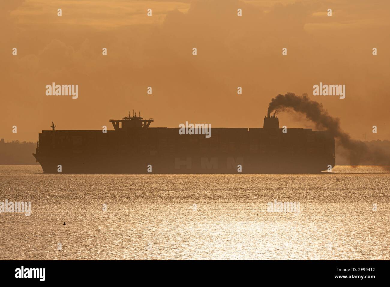 Southend on Sea, Essex, UK. 3rd Feb, 2021. HMM Le Havre is seen passing Southend on Sea on the Thames Estuary late afternoon trailing smoke after leaving DP World London Gateway port. The Algeciras class container ship is one of the largest ever built, entering service in August 2020, able to carry nearly 24000 containers, and serves the Far East Europe 3 loop route. The UK is applying to join the Comprehensive and Progressive Agreement for Trans-Pacific Partnership - or CPTPP – which includes Far Eastern countries served by giant ships such as this Stock Photo