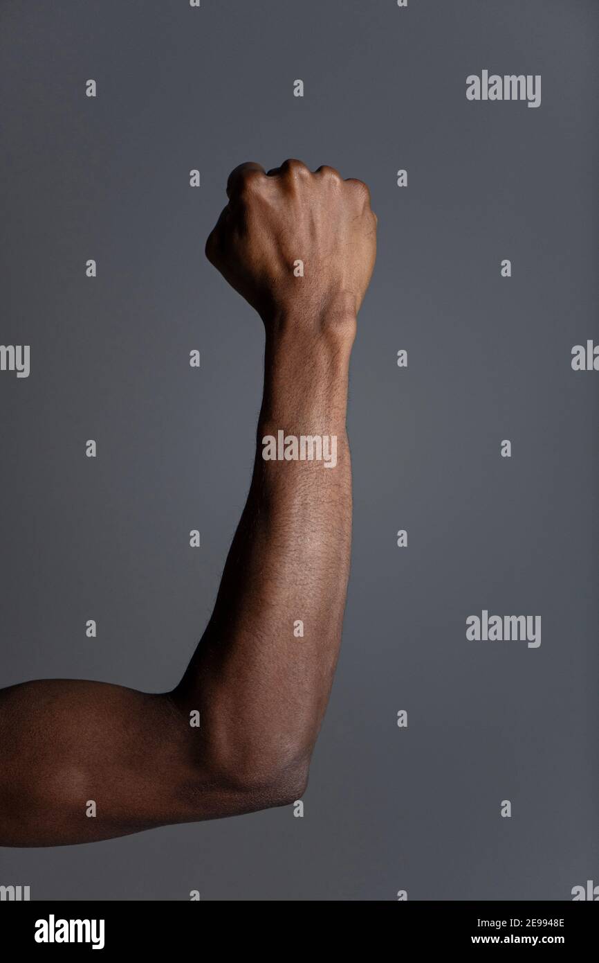 Clenched fist of black male on grey background. Stock Photo