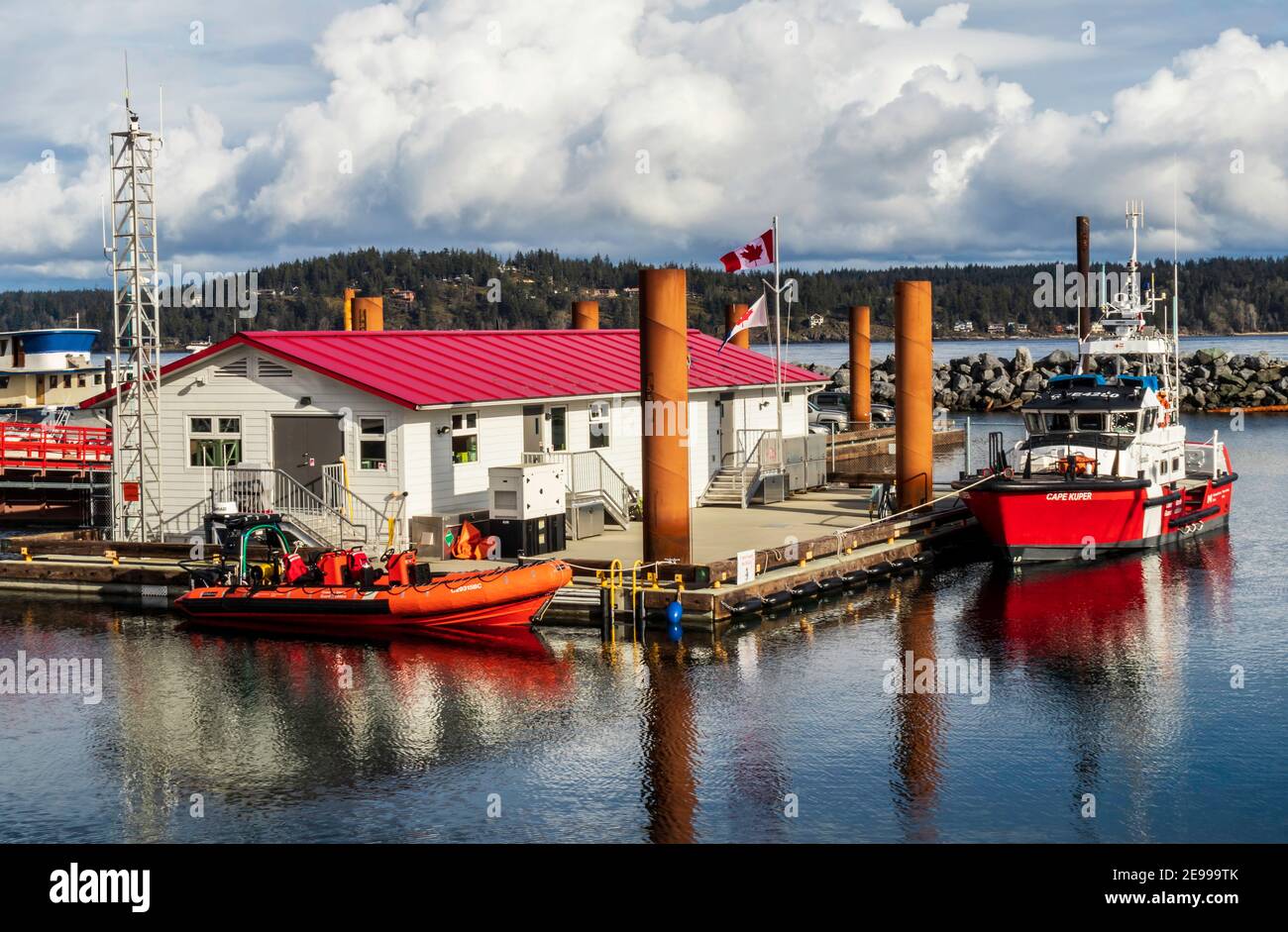 Canadian Coast Guard facility and boats in Campbell River, BC, Canada, a red life boat and a larger rescue ship, red roof on white floating building. Stock Photo
