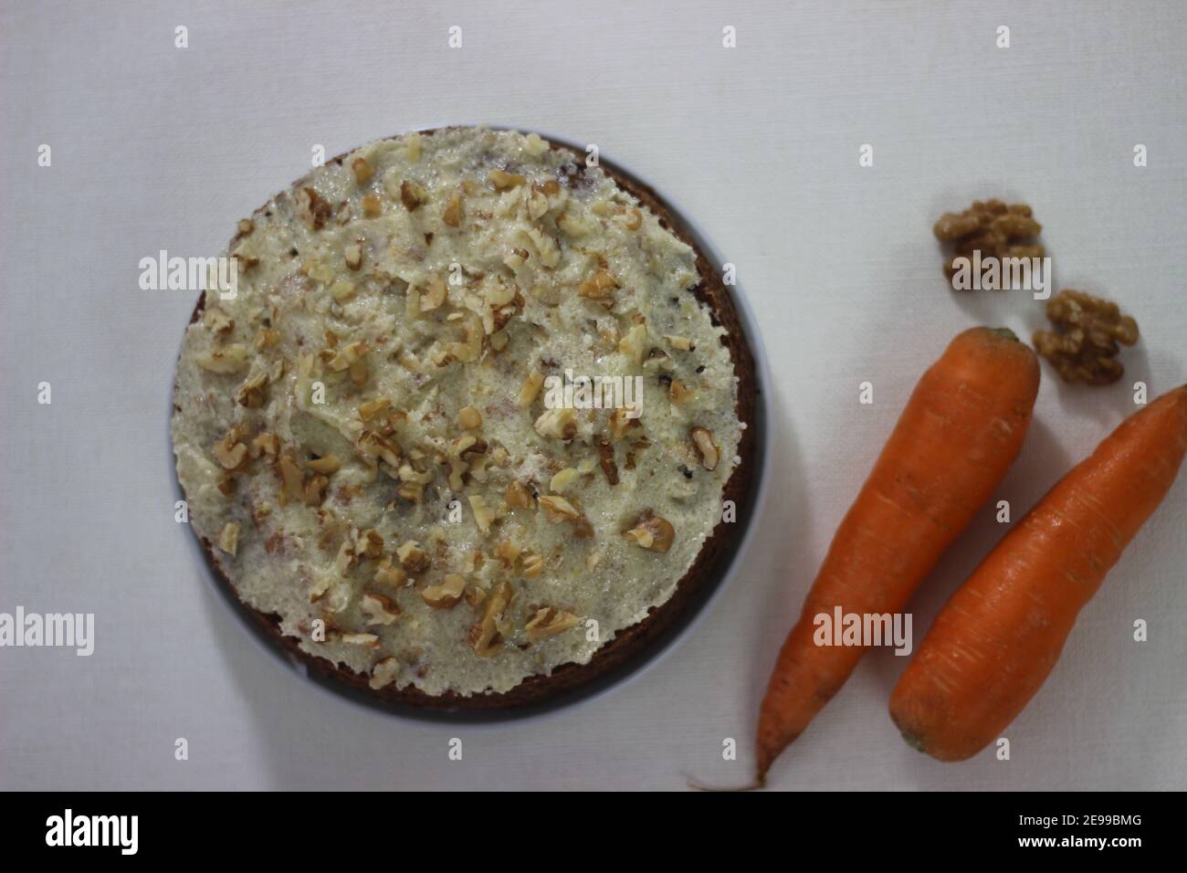 Carrot walnut cake topped with a thin layer of butter, sugar and