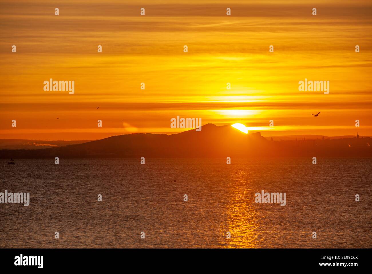 Sunrise over Edinburgh and Arthur's Seat seen from Dalgety Bay, Fife, Scotland. Stock Photo
