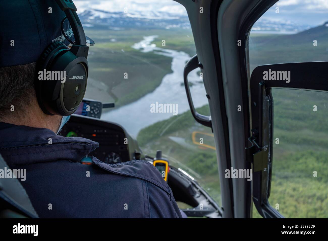 Close up of a Helicopter Pilot in Cockpit flying aircraft over Rivers Stock Photo