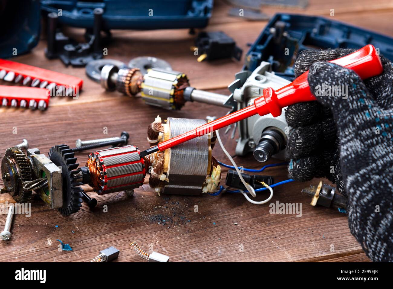 Power tool repair. Details of electrical appliance and repair tools on a wooden table in a repair shop Stock Photo