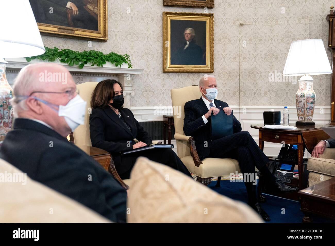United States President Joe Biden, right, wears a protective mask while meeting with U.S. Vice President Kamala Harris, center, and Democratic Senators to discuss the American Rescue Plan in the Oval Office of the White House in Washington on Wednesday, February 3, 2021. Credit: Stefani Reynolds/Pool via CNP /MediaPunch Stock Photo