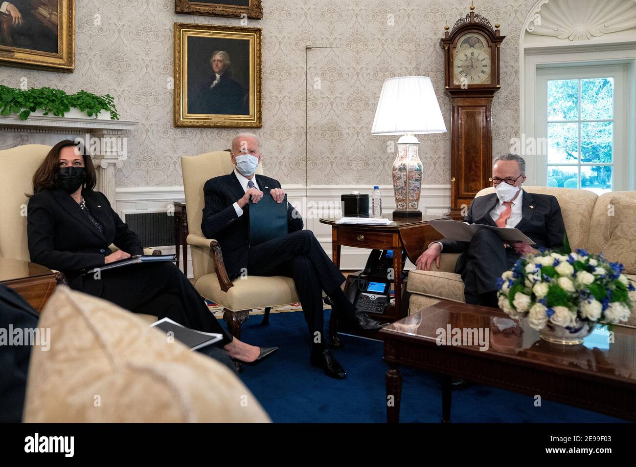 President Joe Biden, center, wears a protective mask while meeting with U.S. Vice President Kamala Harris, left, Senate Majority Leader Chuck Schumer (D-N.Y.), right, and Democratic Senators to discuss the American Rescue Plan in the Oval Office of the White House in Washington on Wednesday, February 3, 2021. Credit: Stefani Reynolds/Pool via CNP /MediaPunch Stock Photo