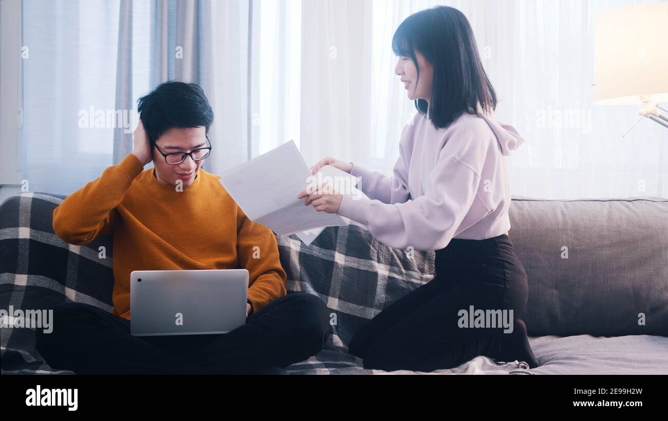 Young couple discussing finances. Woman holding bills while man is using laptop. High quality photo Stock Photo