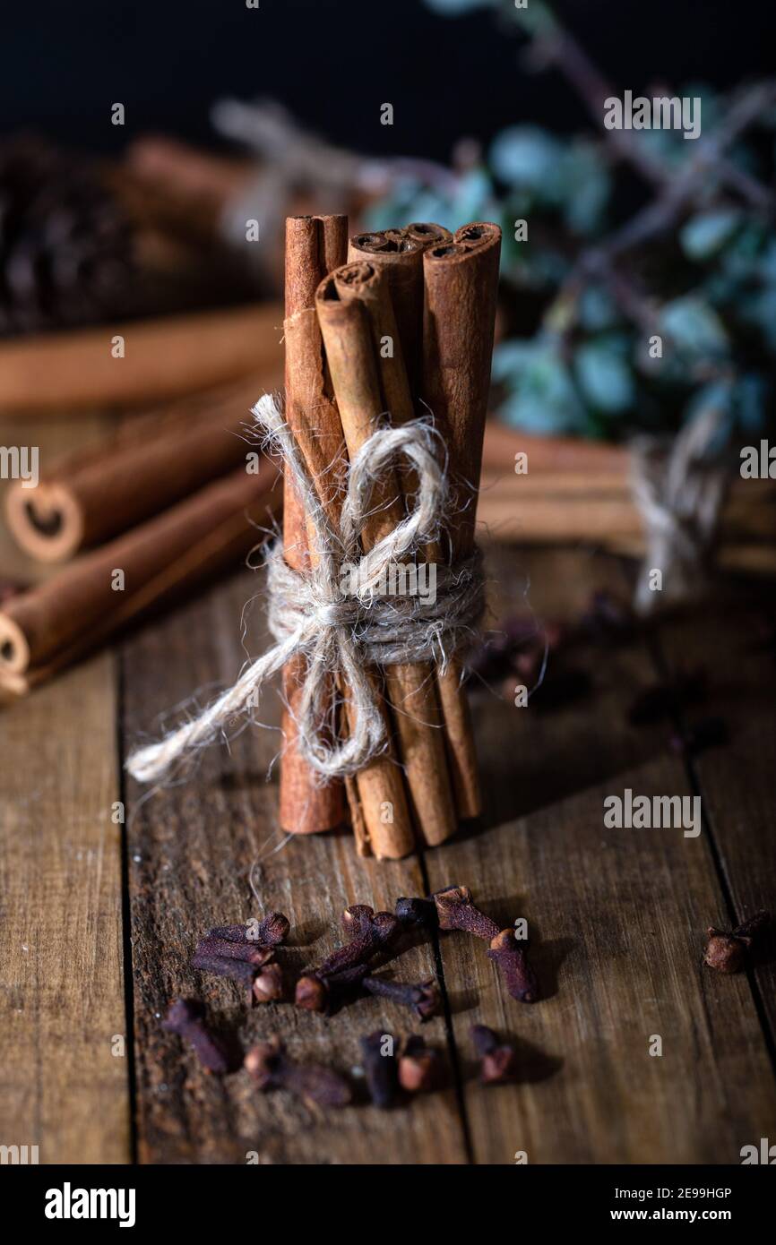 Selection of essential oils with clove and cinnamon sticks on the wooden background Stock Photo