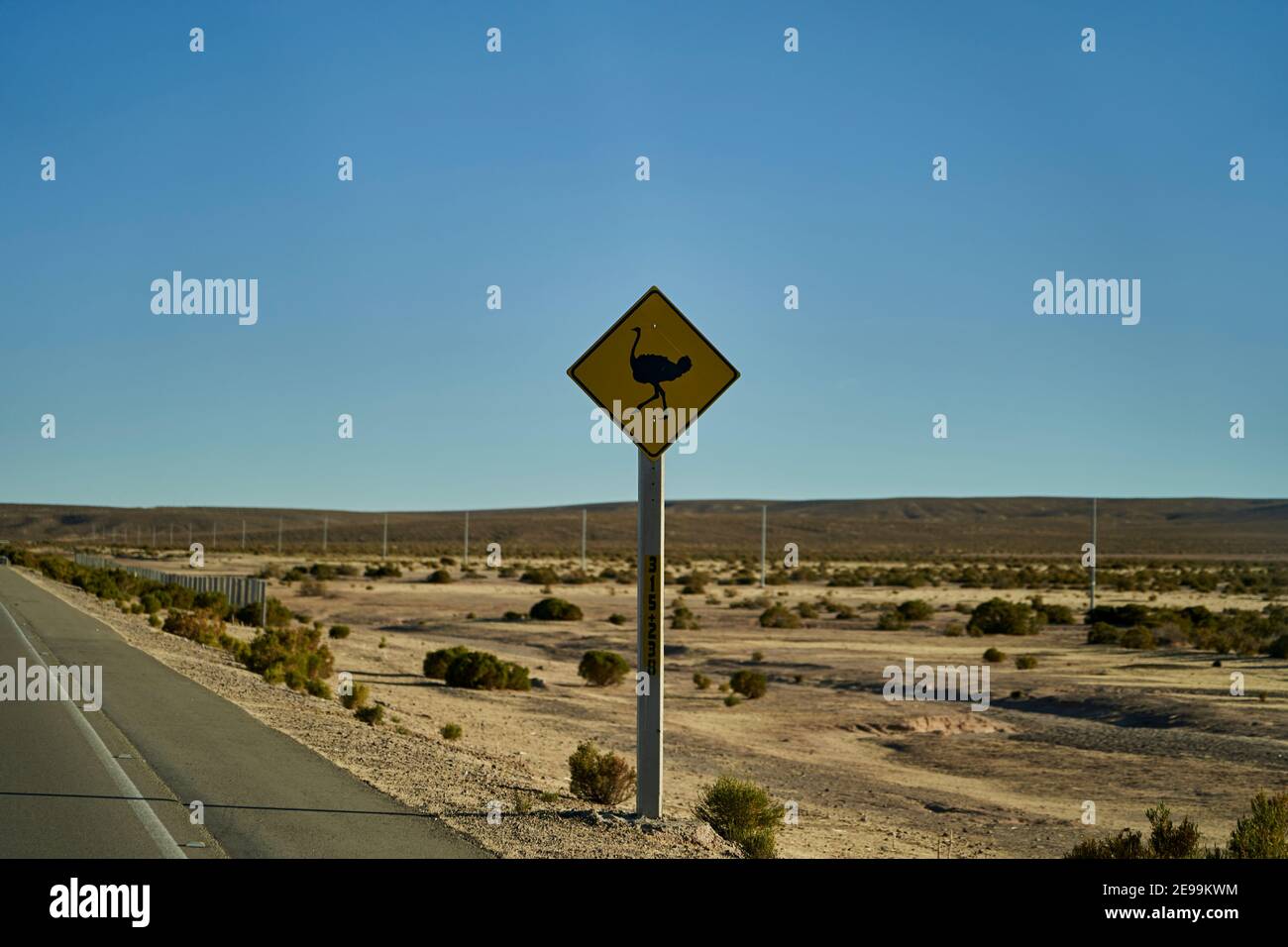 black and yellow road sign standing next to the street in Chile at the ...