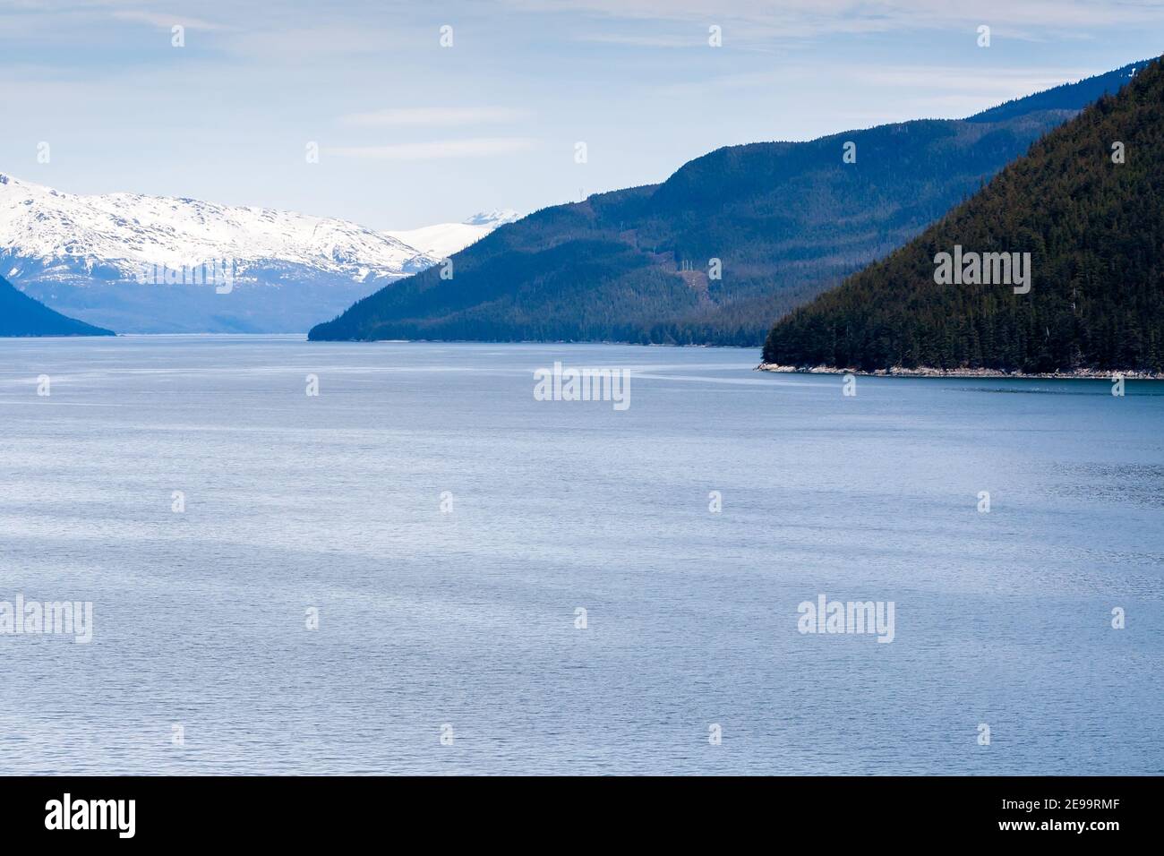 Snow-capped mountains and evergreen trees along the coast of southern Alaska Stock Photo